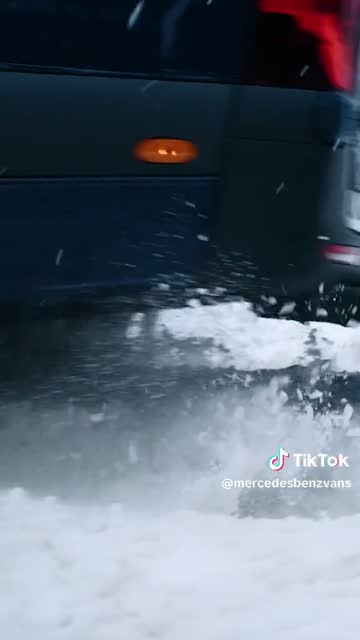 Dark van driving through snow.