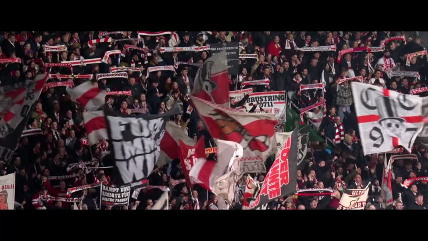 VfB Stuttgart supporters with red and white flags.